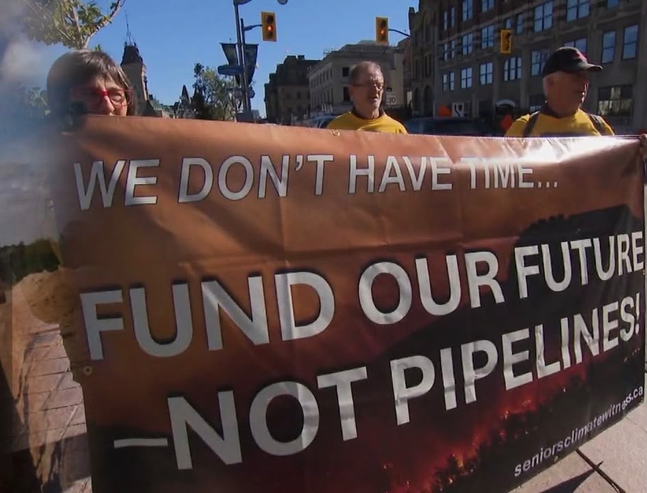 Demonstrators with a banner opposing pipelines; supplied illustrative image, not a protest specifically about Bill C-39