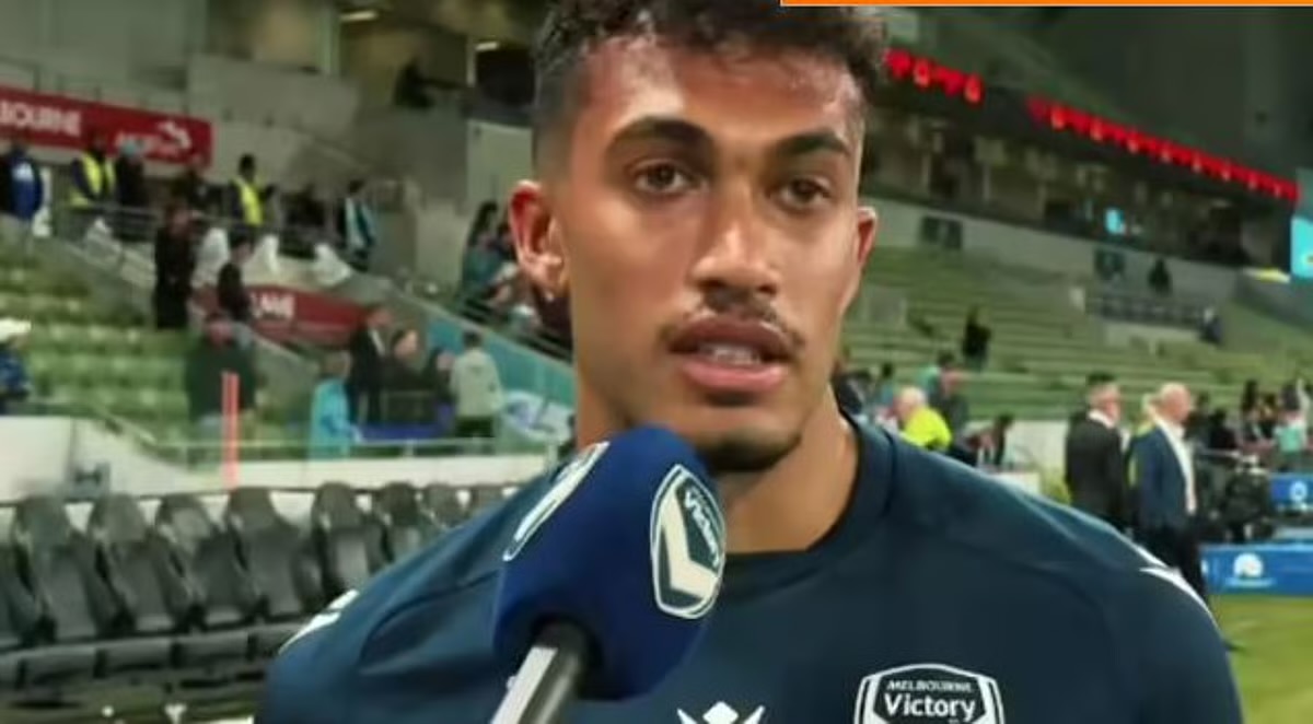 Nishan Velupillay giving an interview in a Melbourne Victory shirt