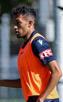 Nishan Velupillay wearing an orange training bib over a Melbourne Victory shirt