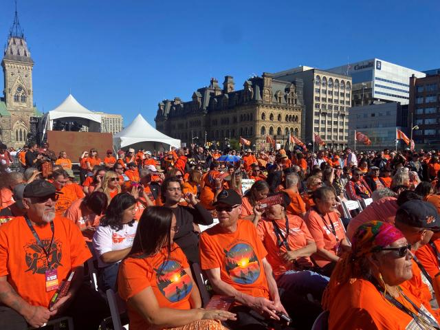 People gathered in orange shirts at a commemoration in Ottawa